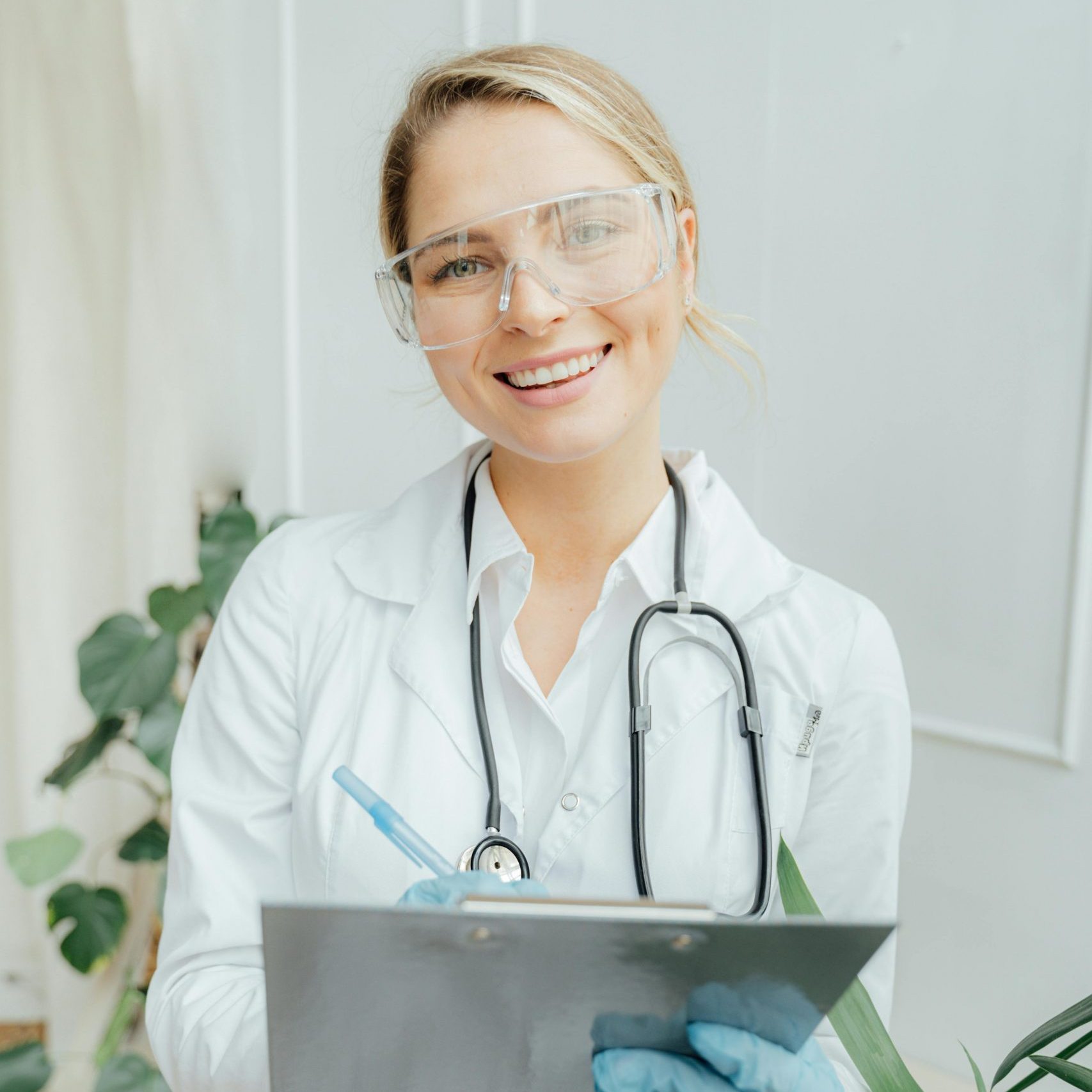Confident female doctor with clipboard in a bright medical office.